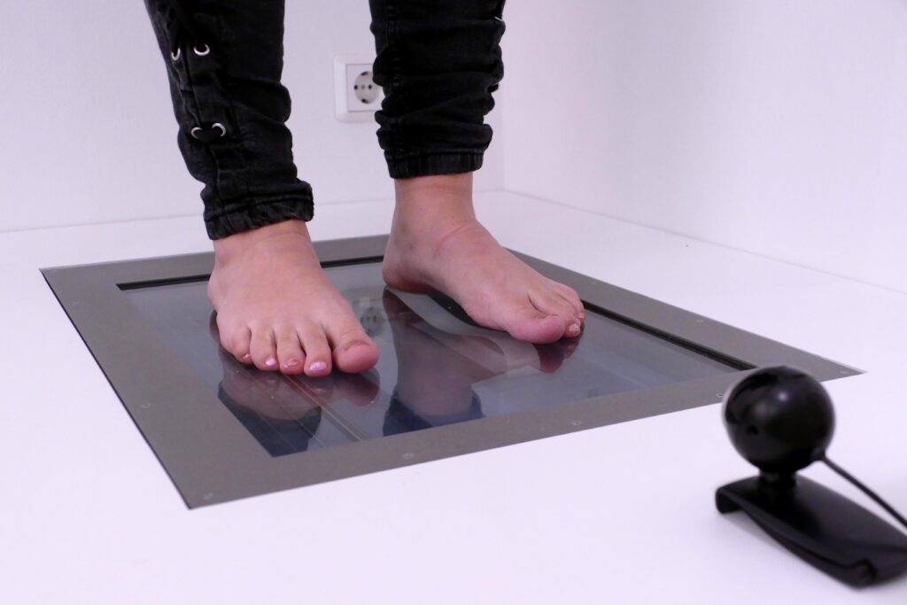 Füße auf digitale Messplatte um Abdrücke für Einlagen zu nehmen